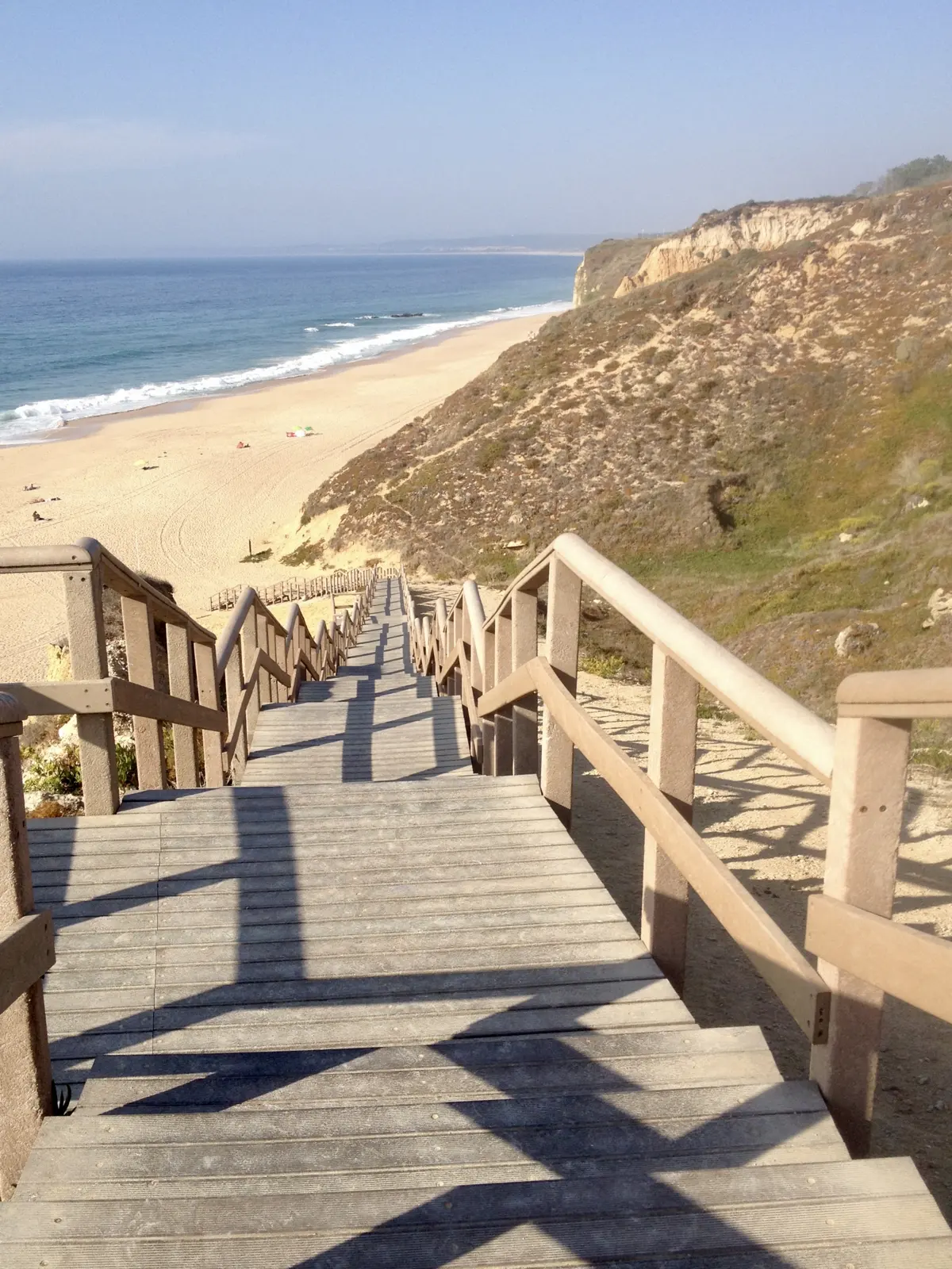 A wooden stairway down the cliff to the Praia das Bicas