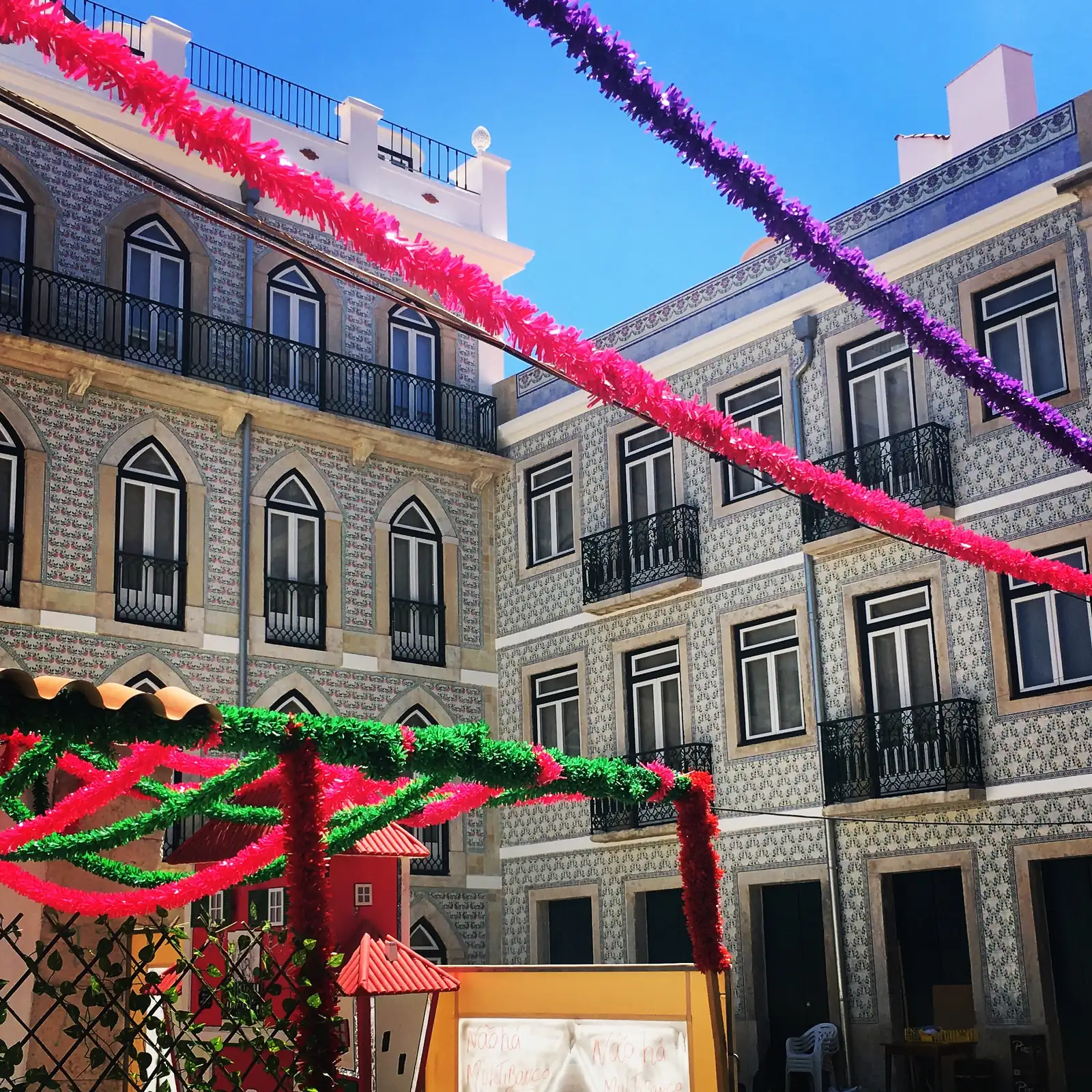 Paper garlands over a tiled street in Alfama for the Santo António festival