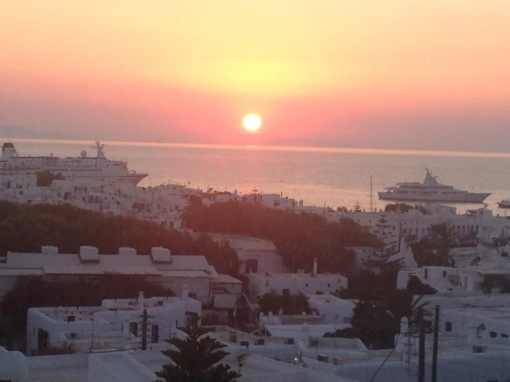 Sunset over Mykonos Town and cruise ships, seen from the Rochari Hotel