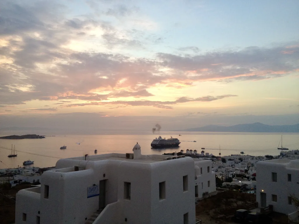 Pink sunset over the harbor and a cruise ship in Mykonos