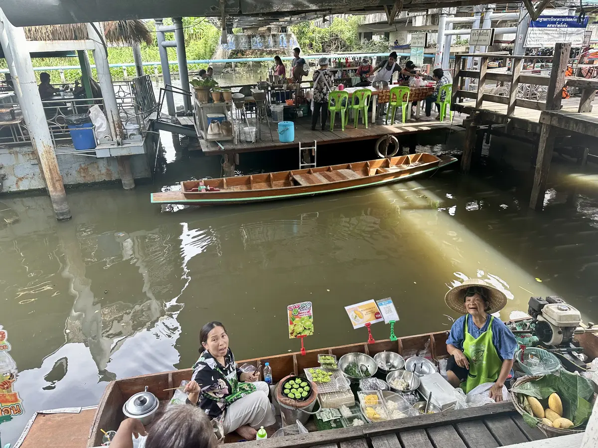 Vendors cooking on boats at Taling Chan floating market, Bangkok