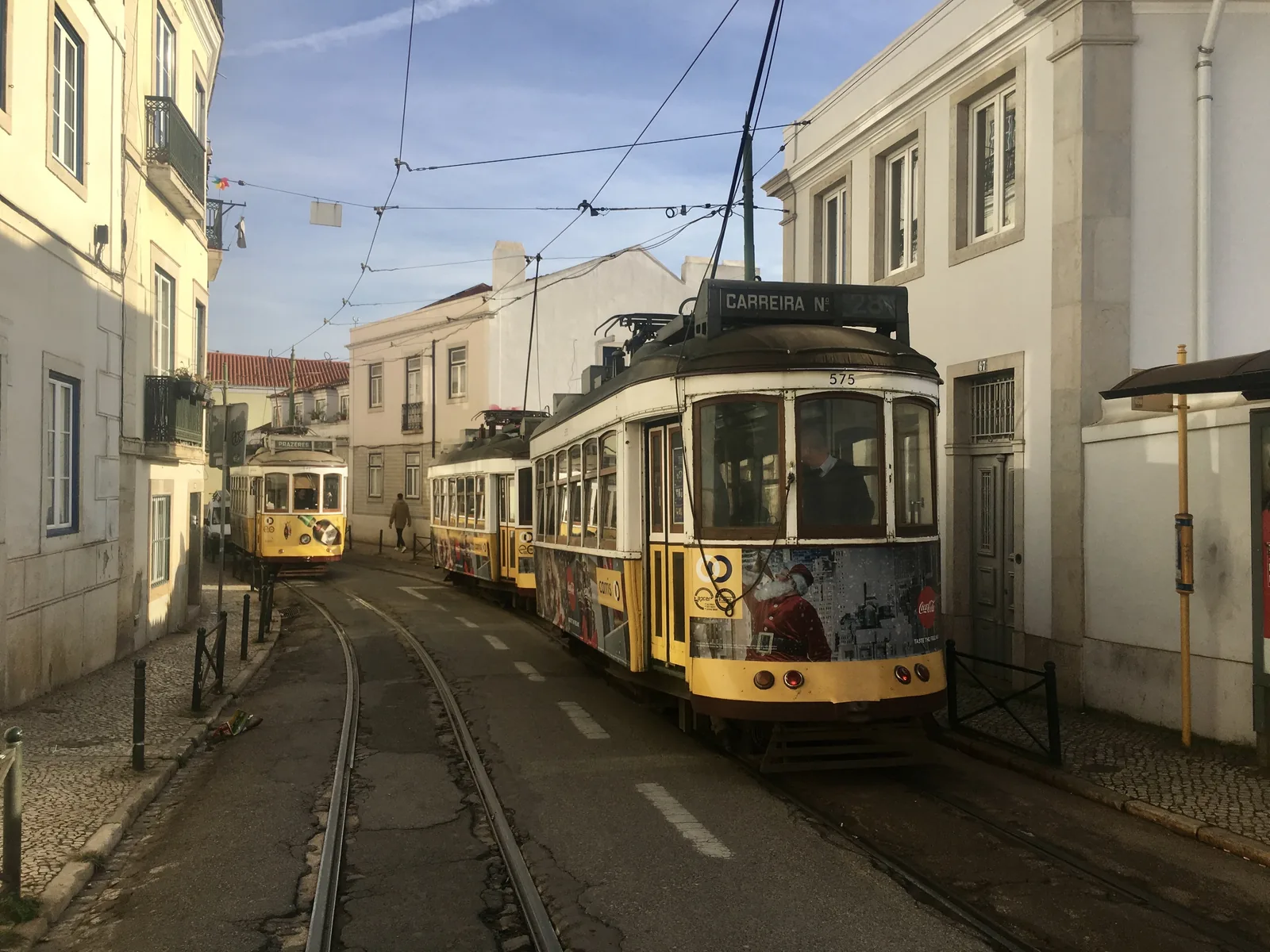 Two yellow tram 28 cars in a narrow street of Alfama, Lisbon