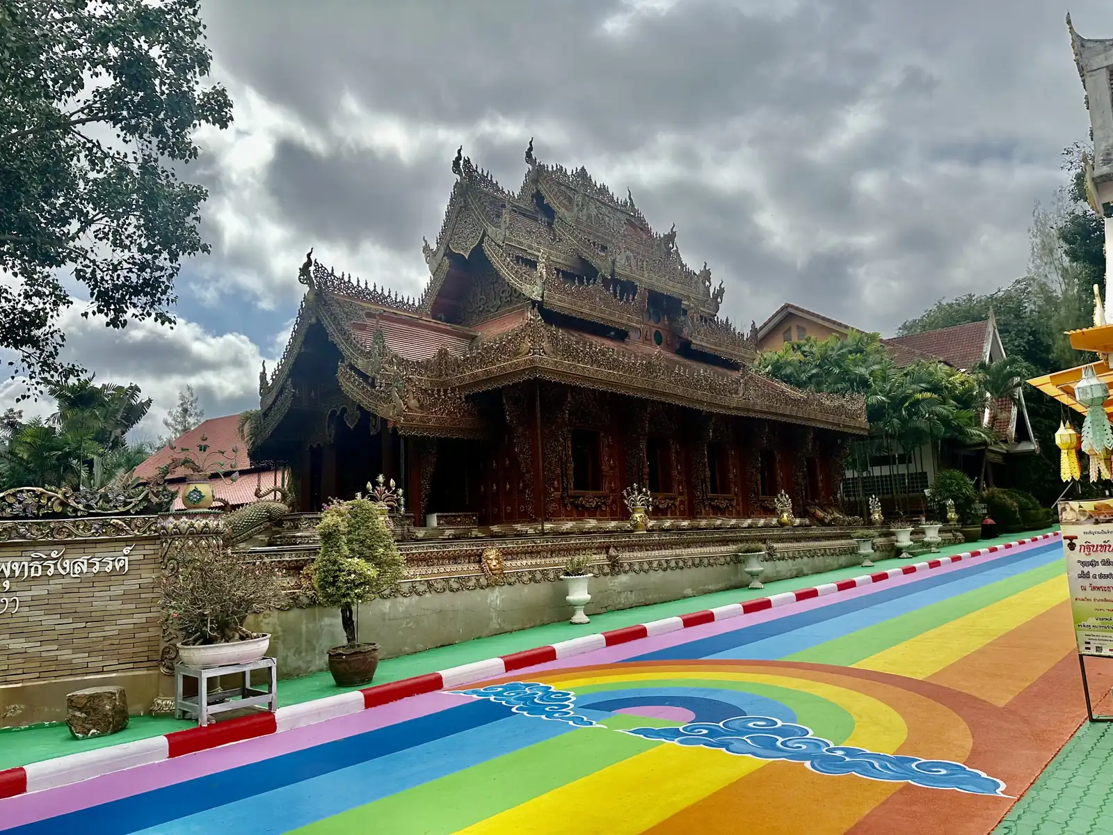In regenboogkleuren beschilderde weg naar een tempel bij Wat Phra That Pha Ngao, Chiang Saen